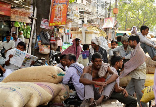 Ngồi nghỉ tránh nóng tại một khu chợ ở New Delhi
